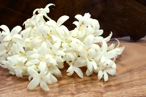 Fragrant white flowers on wooden background.