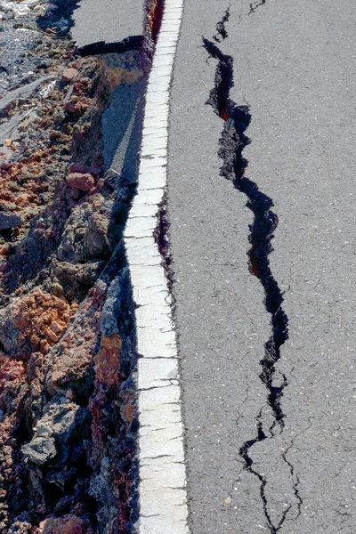 Fissures and erosion of the asphalt road by the earthquake.