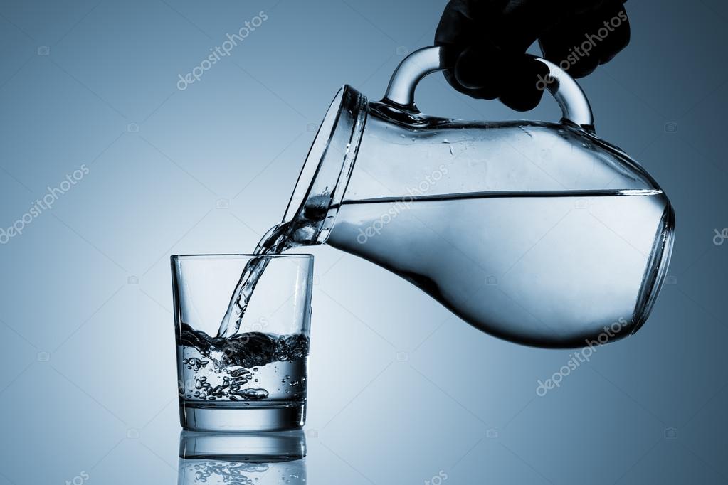 Pouring water from a pitcher into a glass — Stock Photo © trans961