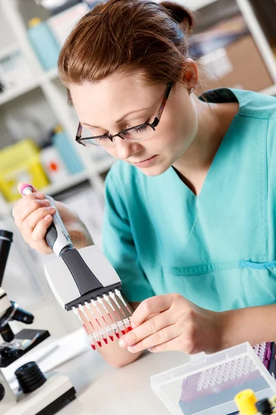 Woman analyzes the genetic code, pipette and microtubes for PCR