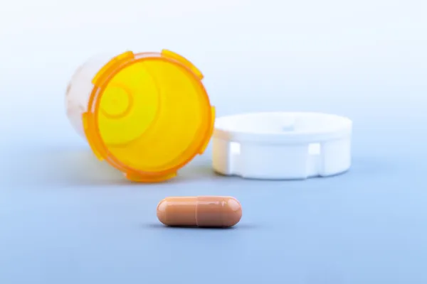 Pills an pill bottle on blue background