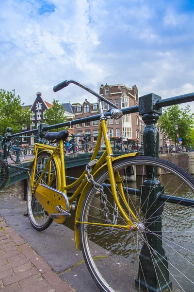 Amsterdam, Netherlands, on July 7, 2014. Bicycle on the bank of the channel. The bicycle is very popular type of transport in Holland