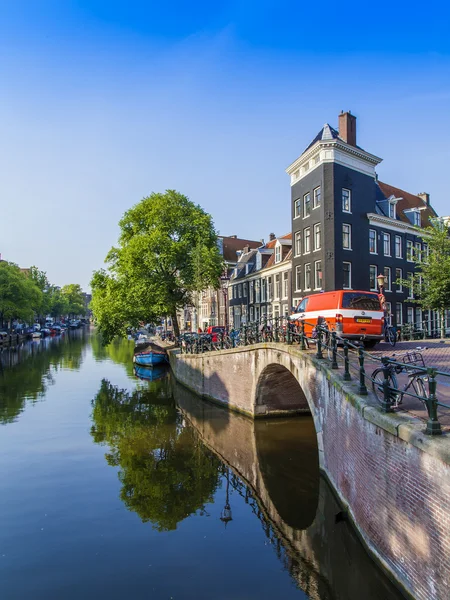 Amsterdam, Netherlands, on July 10, 2014. Typical urban view with old buildings on the bank of the channel and boats moored at bank