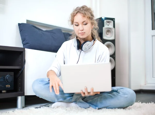 Beautiful woman with laptop sitting on the floor