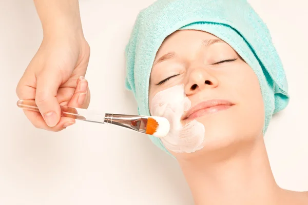 Woman at spa procedures applying mask