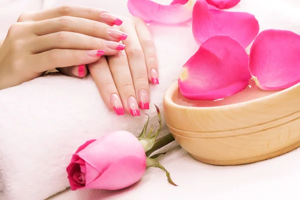 Manicure with fragrant rose petals and towel. Spa