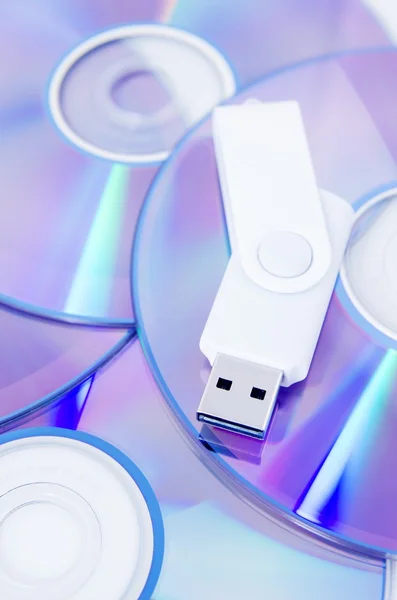 DVD disc and USB flash drive on white background