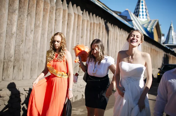 Bride and her bridesmaid walking with friends