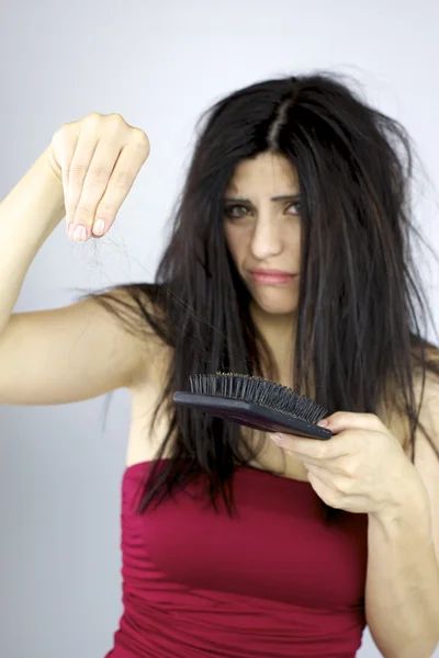 Beautiful woman holding long hair from brushing too hard