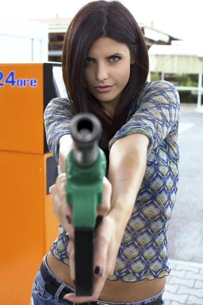 Portrait of female model holding and pointing gas gun