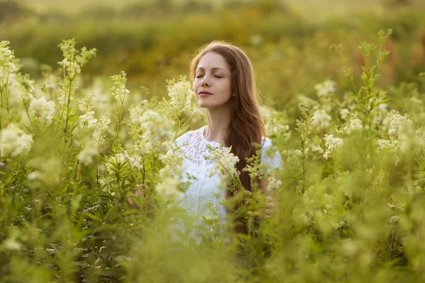 Happy woman with eyes closed among the wildflowers