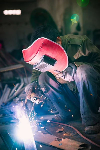 Chinese worker welding metal