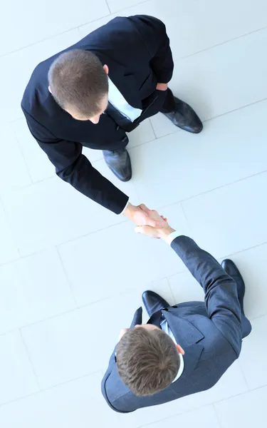 Top view of a two businessman shaking hands - Welcome to business