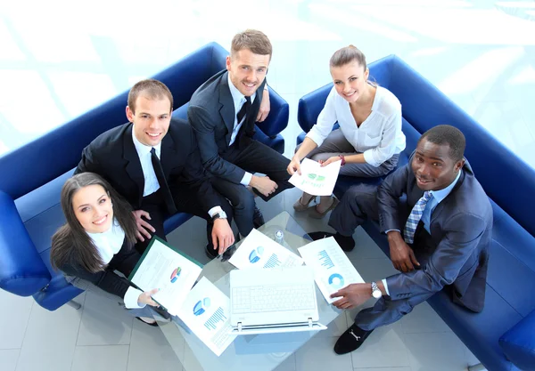 Top view of working business group sitting at table during corporate meeting