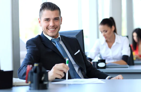 Happy businessman sitting in office