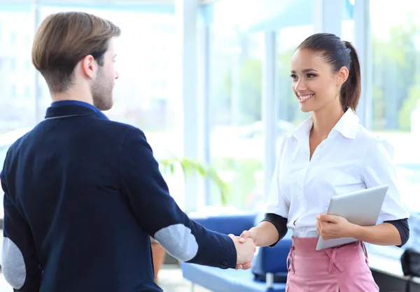 Cheerful businesspeople, or businesswoman and client handshaking