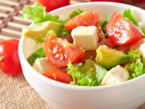 Salad with avocado, cherry tomatoes and mozzarella with honey-bacon dressing