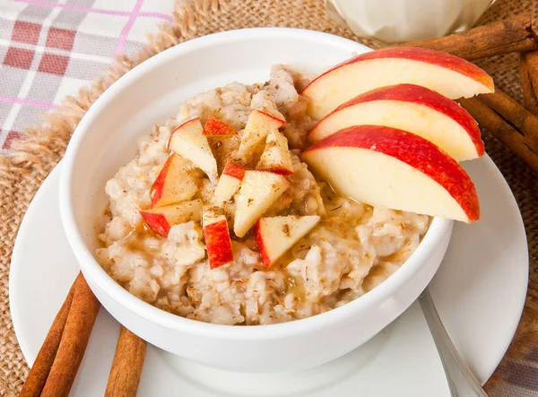 Oatmeal with apples and cinnamon in a white bowl