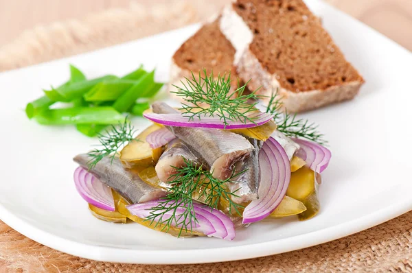 Herring salad with pickled cucumbers and onions