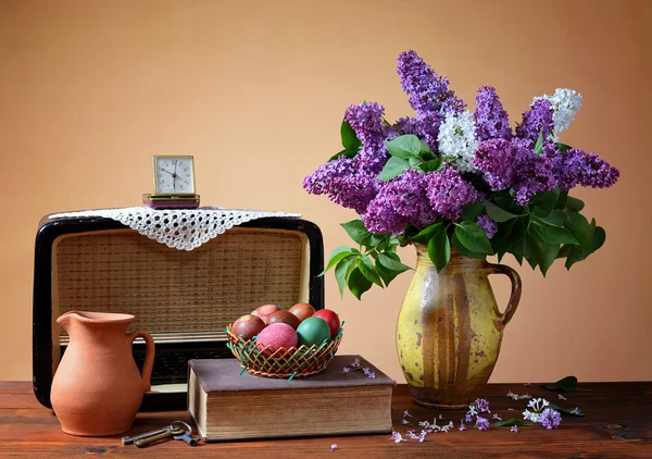 Lilac in a vase, old radio and easter eggs