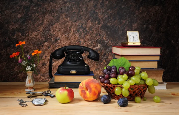 Old phone, fruit and books