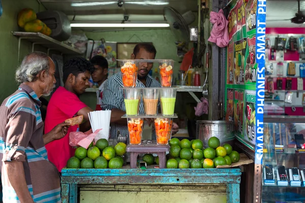 Local man buying fruit juice from street vendor