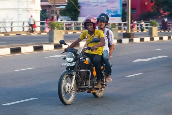 Local men riding motorcycle on street of Galle