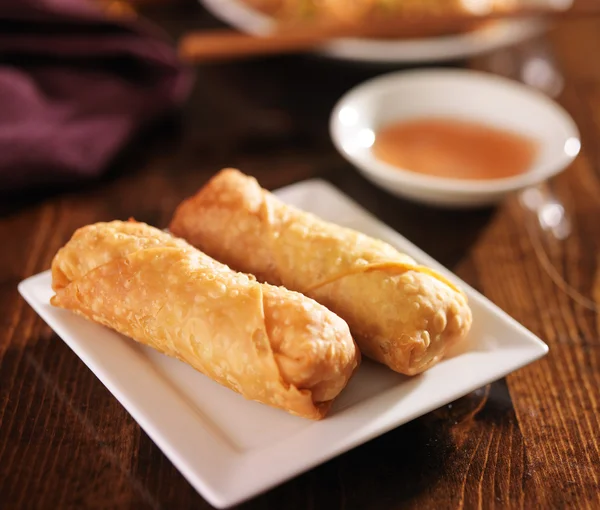 Two chinese egg rolls on plate