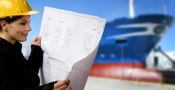 Female naval engineer with ship under construction
