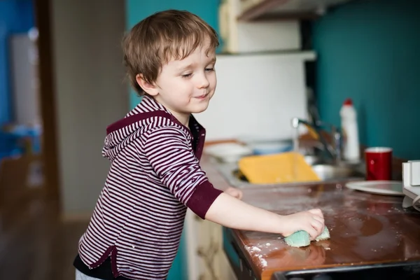 Boy cleaning the kitchen