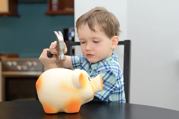 4 year old boy is preparing to break the piggy bank