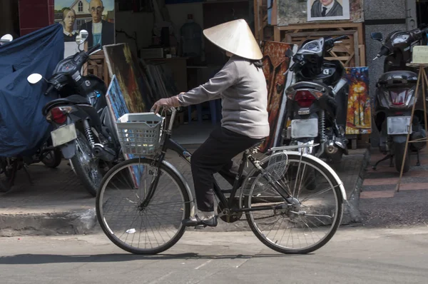 HO CHI MINH CITY, VIETNAM-NOV 3RD: A woman cycles down a street