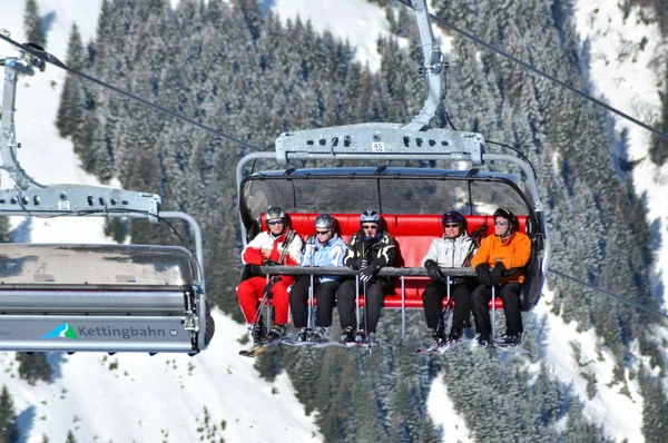 Skiers going up with a ski lift in the Alps