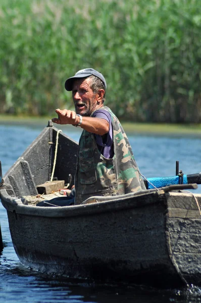 Fisherman in a boat in the Danube delta, Romania