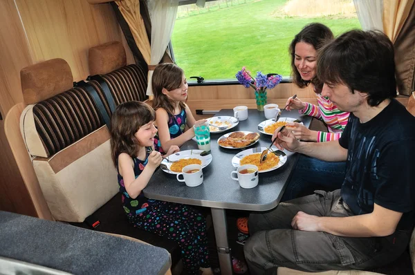 Family eating together in RV interior