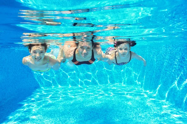 Happy family swim underwater in pool