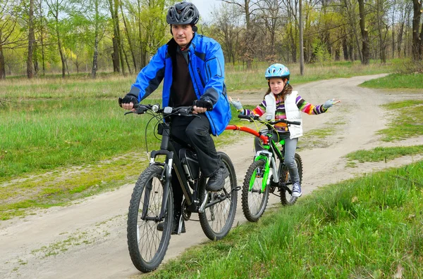 Happy father and child on bikes, family cycling