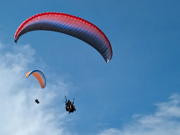 Paragliding against clear blue sky