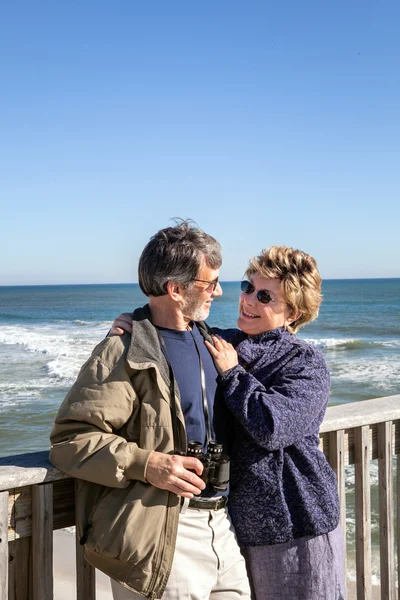 Retired senior couple hugging on sunny Florida fishing pier