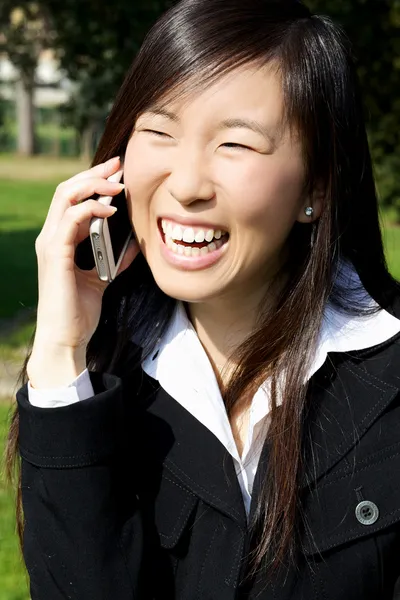 Happy asian woman on the phone laughing