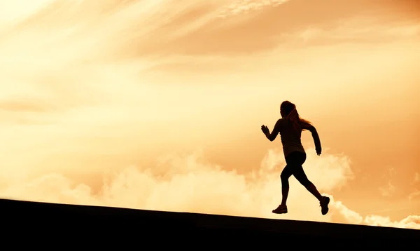 Female runner silhouette, running into sunset
