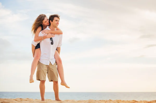 Romantic happy couple on the beach at sunset, man and woman in l