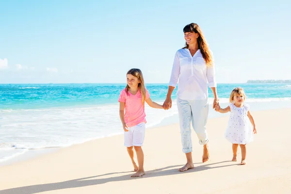 Mother and daughters walking on the beach