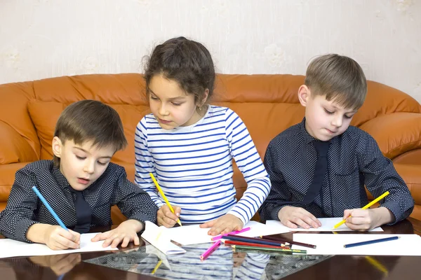 Children draw with crayons on paper