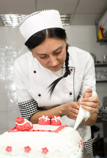 Pastry chef decorates a cake