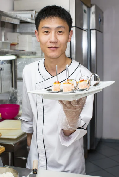 Japanese chef with a plate of sushi