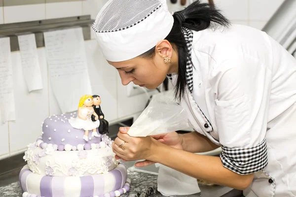 Pastry chef decorates a cake