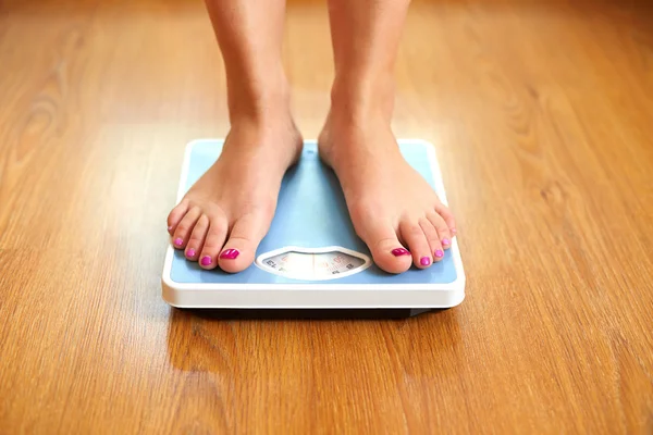 Female bare feet with weight scale