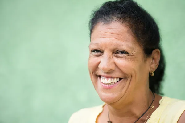 Portrait of happy old hispanic woman smiling at camera