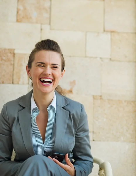 Laughing business woman sitting on chair